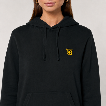 Official Avenue Q pin badge worn on a black hoodie at chest level