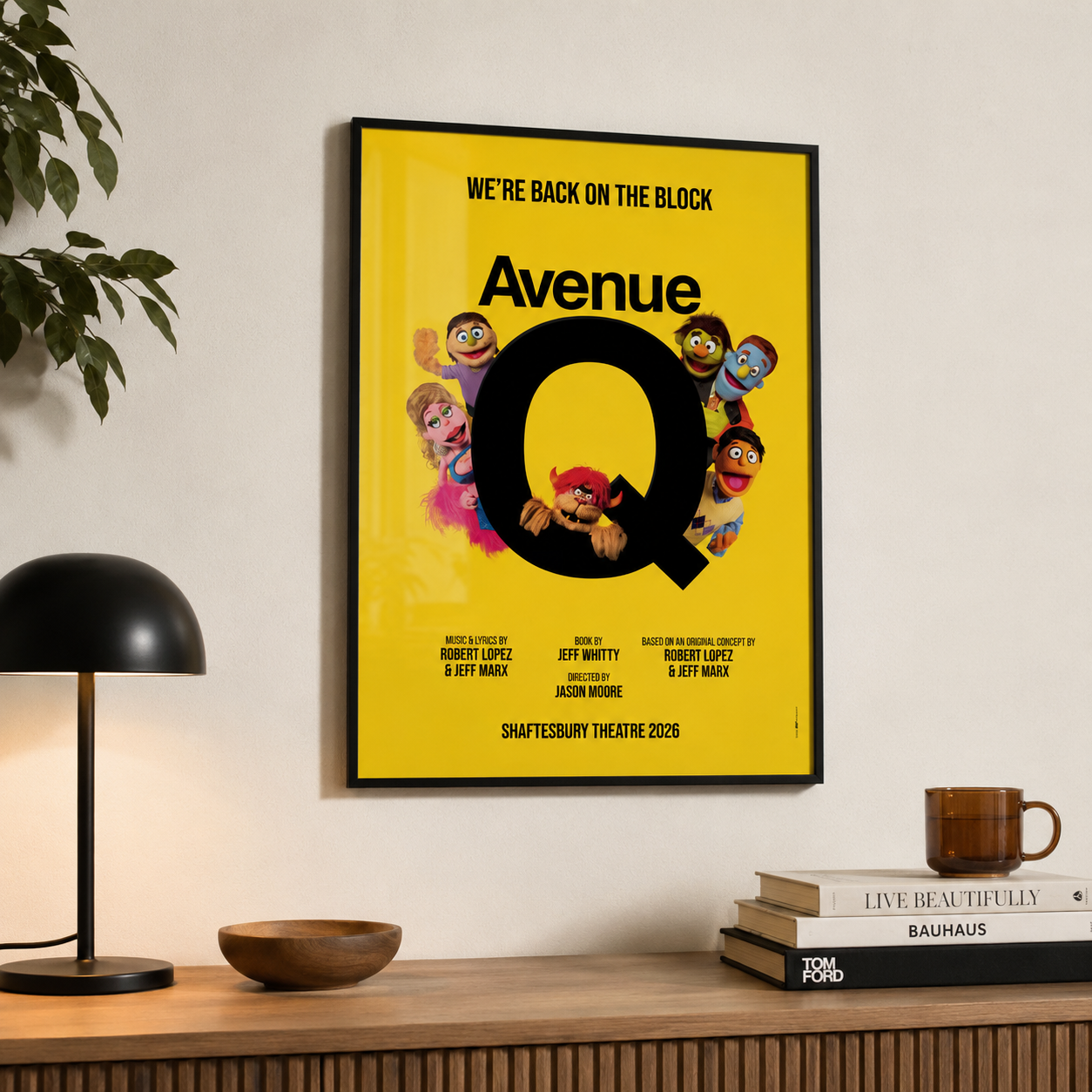 Official Avenue Q A3 glossy poster from the 2026 West End run at the Shaftesbury Theatre, displayed in a black frame on a wall